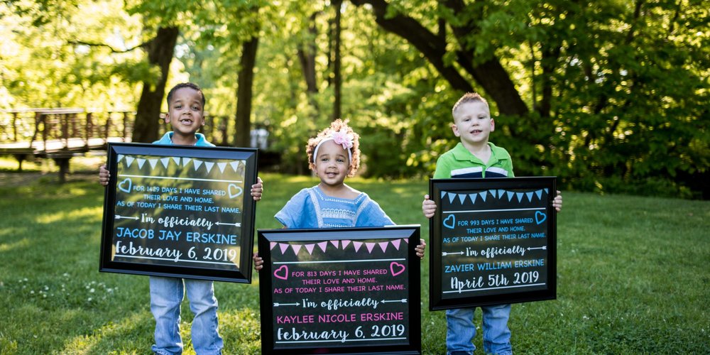 three little kids holding framed message