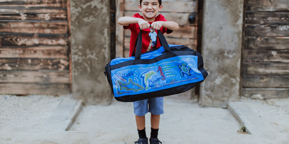 little boy holding a bag