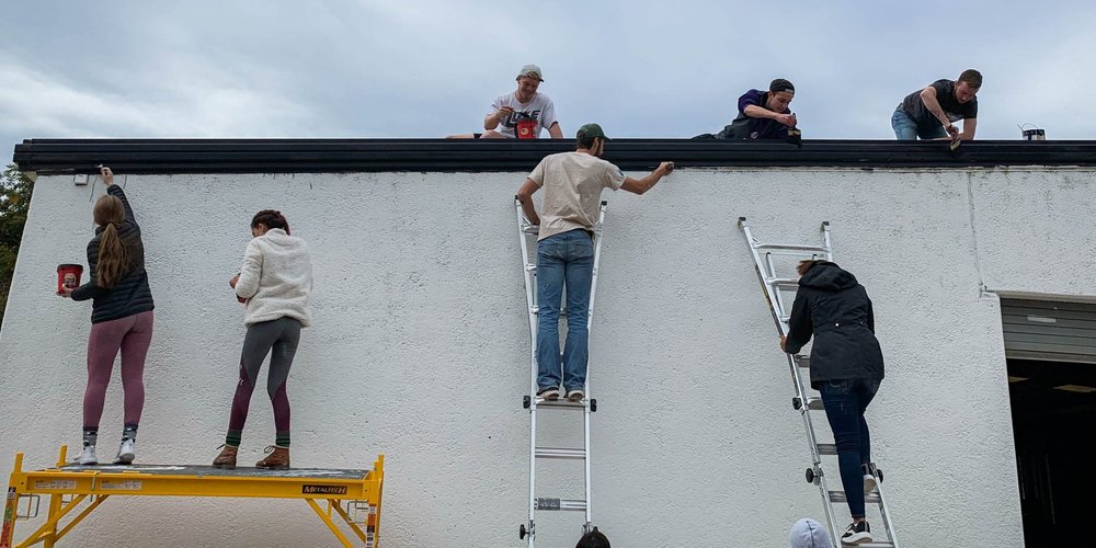 Foster Care Volunteers Painting Building for community involvement