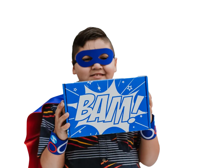 boy dressed as superhero holding a superhero box