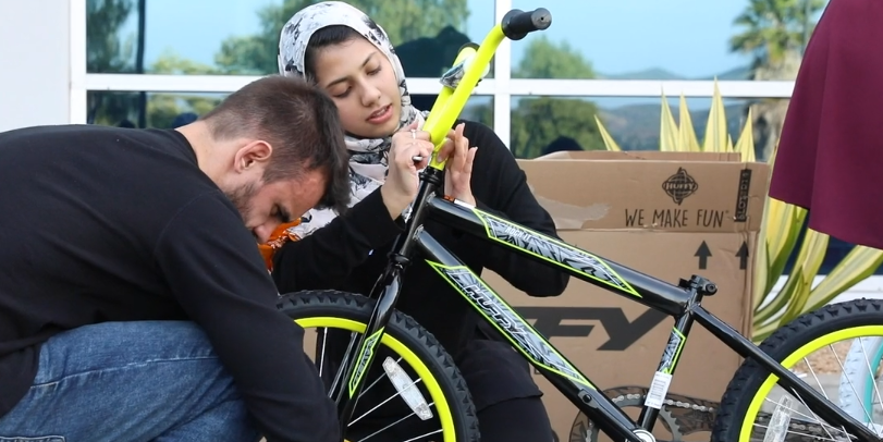 man and woman fixing a bike