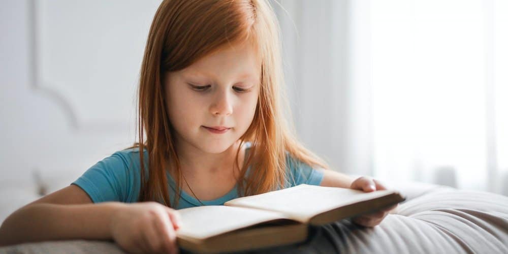 girl in blue t-shirt reading