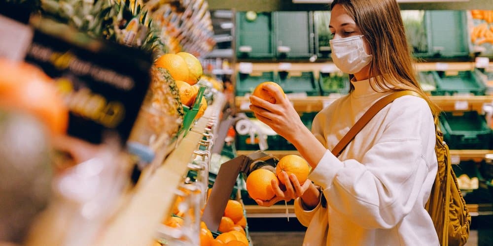 woman at the grocery buying oranges