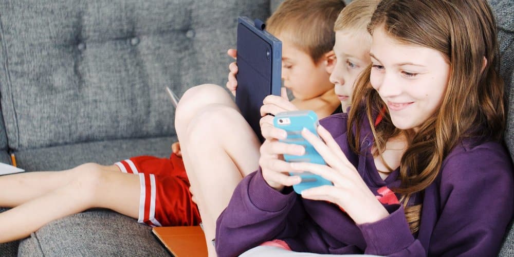 photo-of-kids-sitting-on-gray-sofa