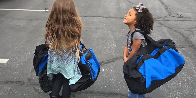 cute little girls with duffle bag