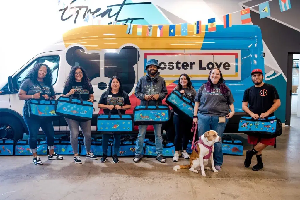 volunteers holding sweet cases standing in front of foster love van