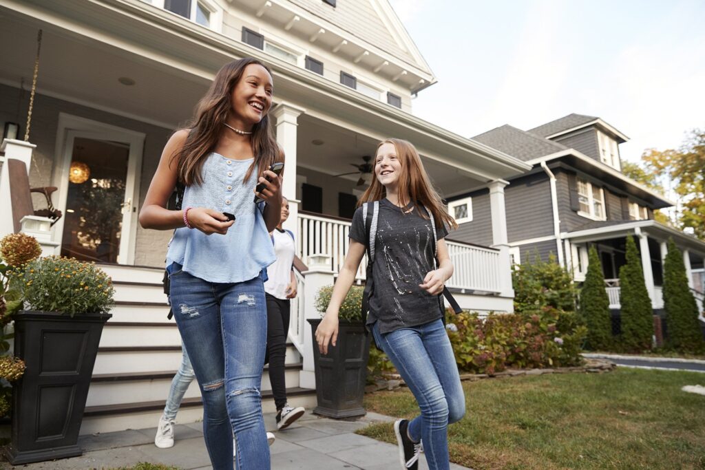 teen girls leaving house for school