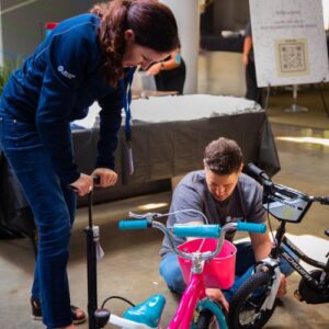Two volunteers helping build bikes in the build a bike program