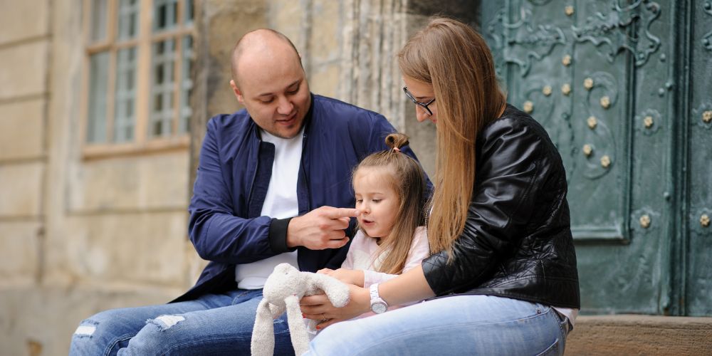 two parents sitting with a young girl