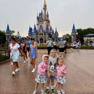 Levi and his sisters posing in front of Cinderella's Castle