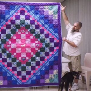 Inmate holding up quilt