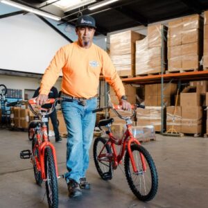 Man carrying two completed bikes