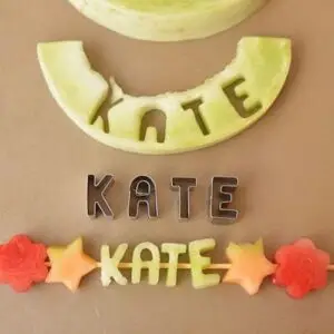 letters cut from a melon and arranged into a name on a skewer
