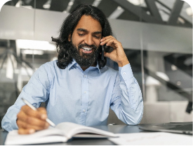 Person listening on phone and taking notes