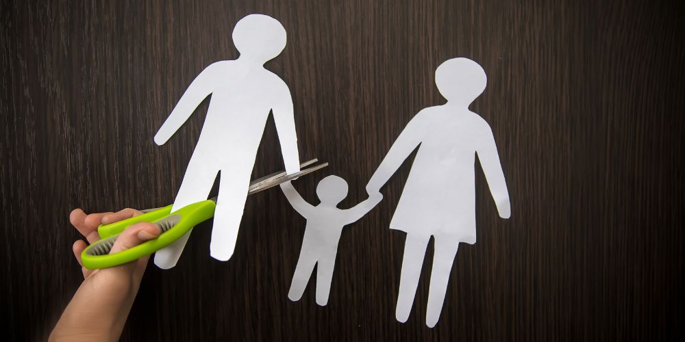 scissors cutting a paper cutout of a family symbolizing termination of parental rights