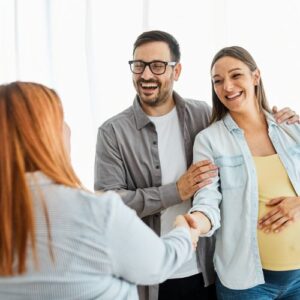pregnant couple shaking hands with attorney