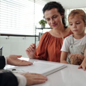Mom signing paperwork with child