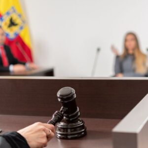 blurry courtroom setting with a judge holding a. gavel in the foreground
