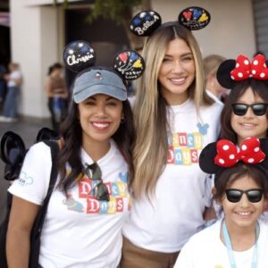 Chrissie Fit and Belle-a at Disney Days posing with kids in edited sunglasses