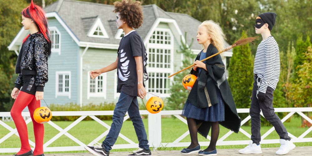 Kids practicing Halloween safety while trick or treating in their costumes