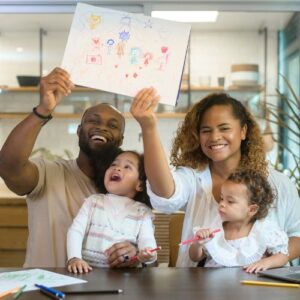 Parents sitting with kids and holding up a drawing they made together