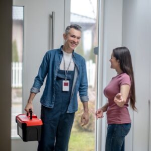 woman letting in repairman so she will pass home inspection checklist for foster care