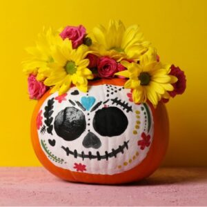 A pumpkin painted to look like a sugar skull