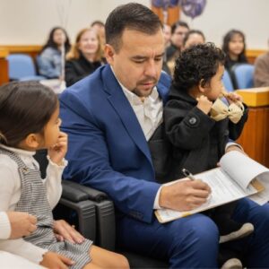 Dad signing adoption papers in a courtroom