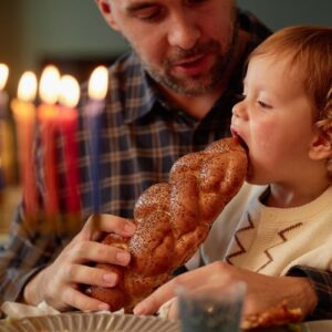 father sharing challah with his son