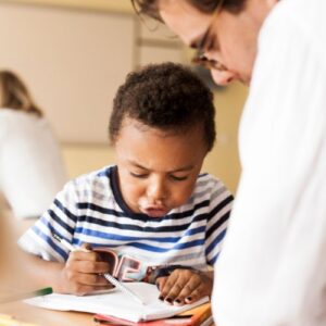 A doctor supervising a child who is coloring