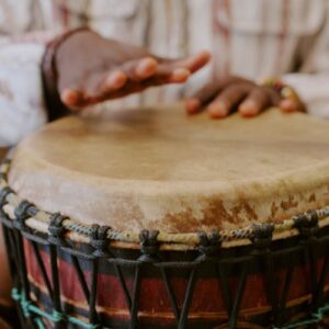 Hands playing a djembe drum