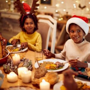 Kids eating dinner with Christmas hats