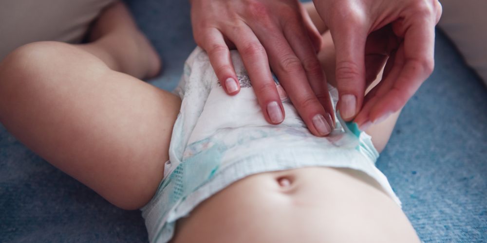 Mother changing baby diaper