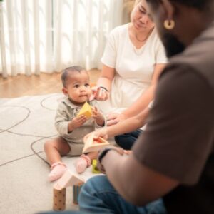 baby playing with blocks, looking up at his dad