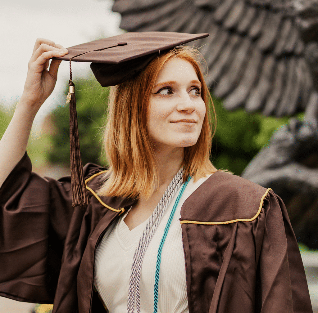 Foster Love Family Fellowship graduate starting to remove her graduation cap.
