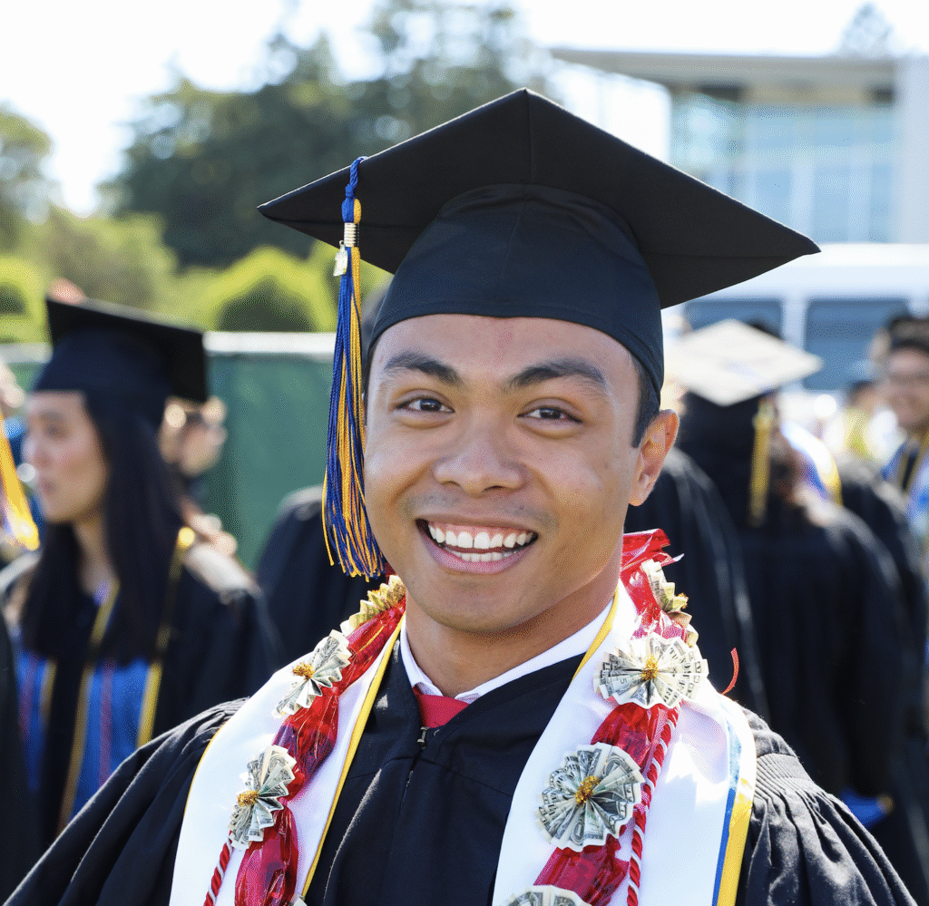 Foster Love Family Fellowship smiling at his graduation in a cap and gown