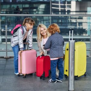 Woman meeting two children at an airport with their luggage they received through senate Bill S3781