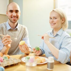 two coworkers painting eggs for an easter egg team building activity