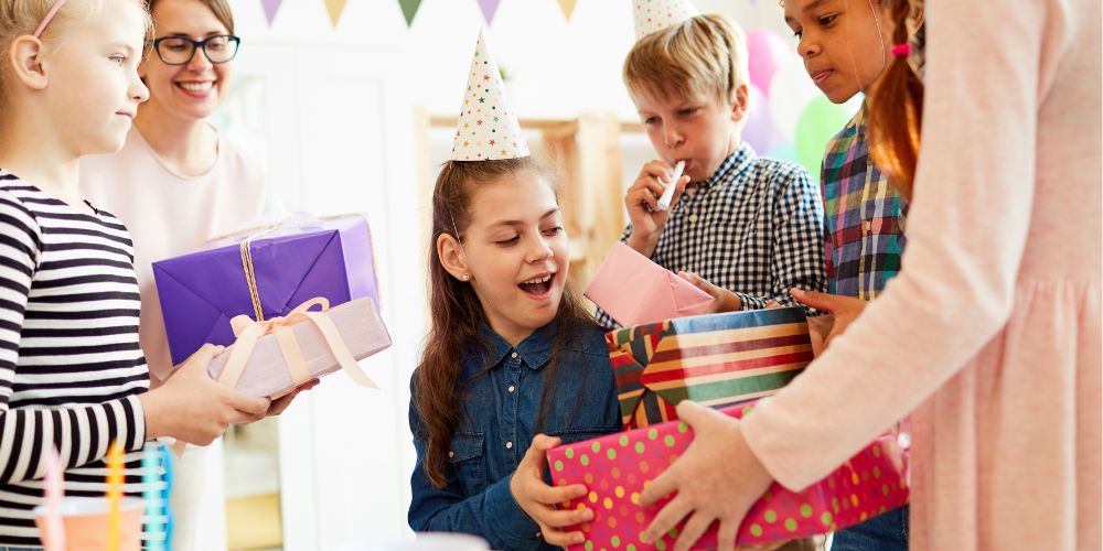 girl getting gifts at her birthday party
