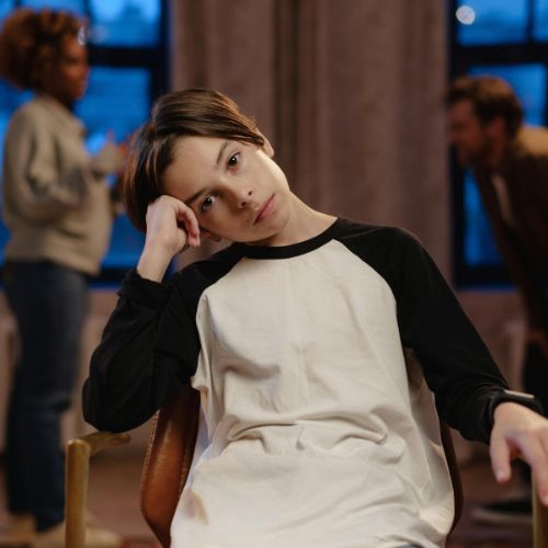 boy facing camera with parents arguing in the background