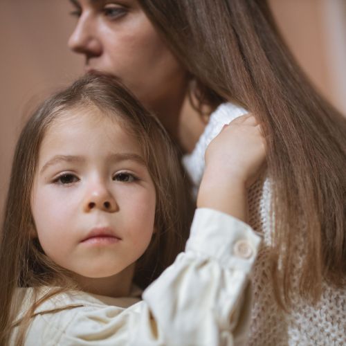 woman holding daughter serious
