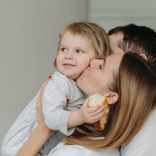 mother kissing daughter on cheek