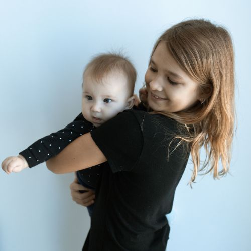 girl holding baby sibling