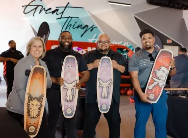 Gallery_3 4 people showing off Pokemon skateboards they helped assemble