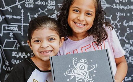 girls holding a shared STEM box