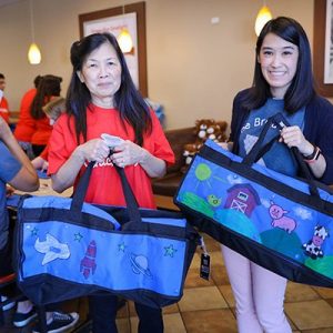 two volunteers holding up decorated sweet cases